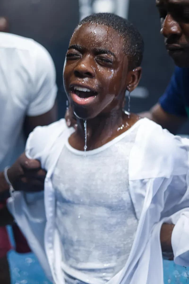 A young person rejoicing moments after baptism
