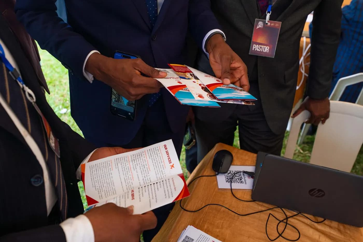 Brochures changing hands across a stand at the fair