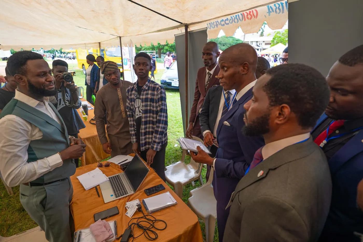 An exhibitor demonstrating on a laptop to a group of delegates