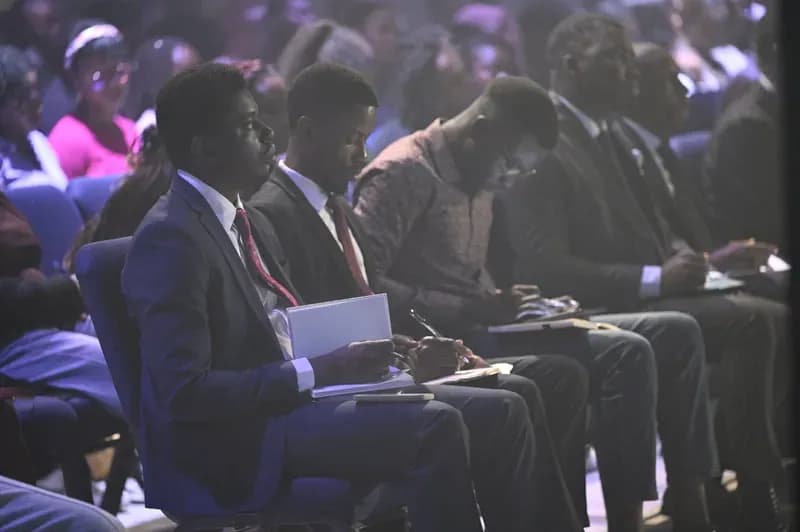 Young men in suits taking notes during a session